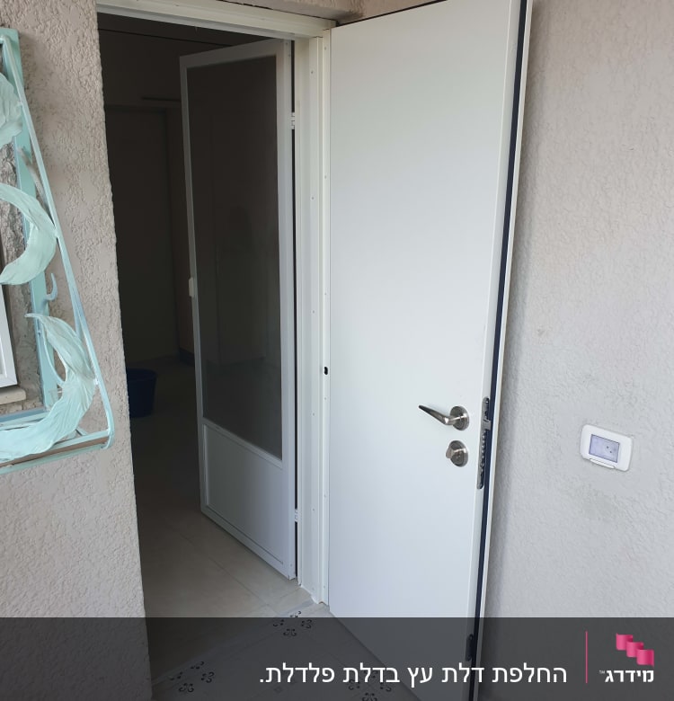 דלת לבנה פתוחה עם ידית מתכת